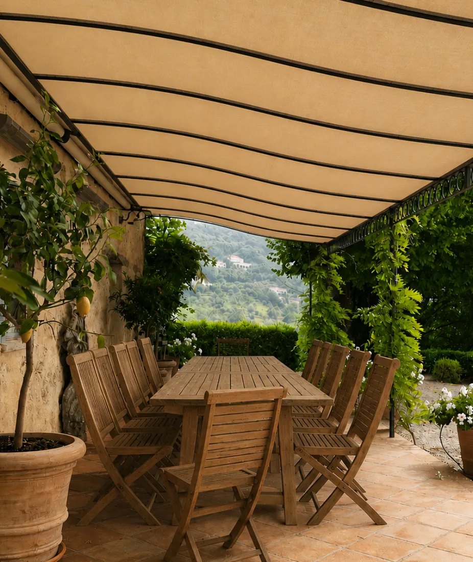 Toile beige tendue en pergola au-dessus d'une table de jardin dans un décor méditerranéen